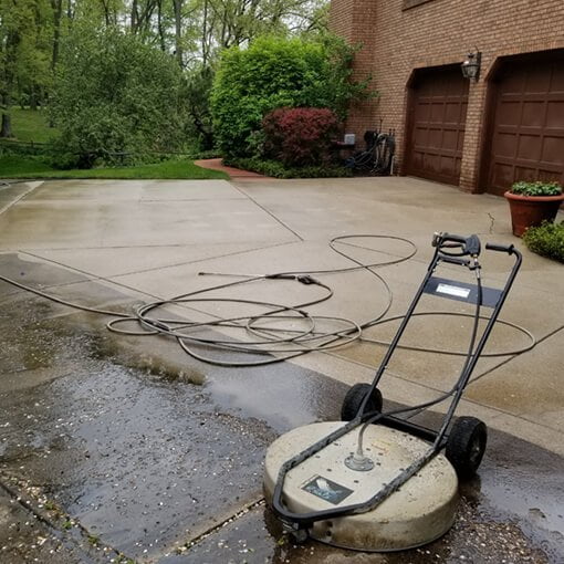 Power Washer on a House’s Driveway | Fire Restoration